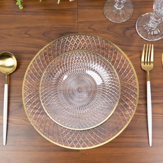 Elegant clear glass plates with gold rim on a wooden table setting.