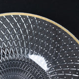 Cut glass plate with intricate diamond pattern and gold rim.