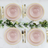 Elegant pink plates with gold trim arranged on a marble table with greenery accents.