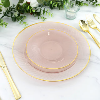 Elegant pink dinnerware set with gold trim on a marble table.