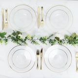 Elegant gold-rimmed dinner plates set on a marble table with greenery accents.