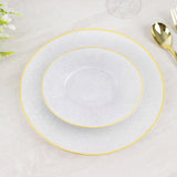 Elegant white dinnerware set with gold accents on a wooden table.