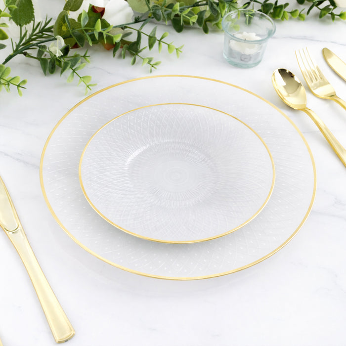 Elegant clear plates with gold trim on a marble table setting.