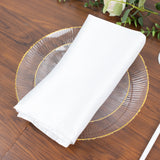White napkin elegantly folded on a glass plate.