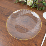 Clear decorative plate with ribbed design and yellow edge on wooden table.