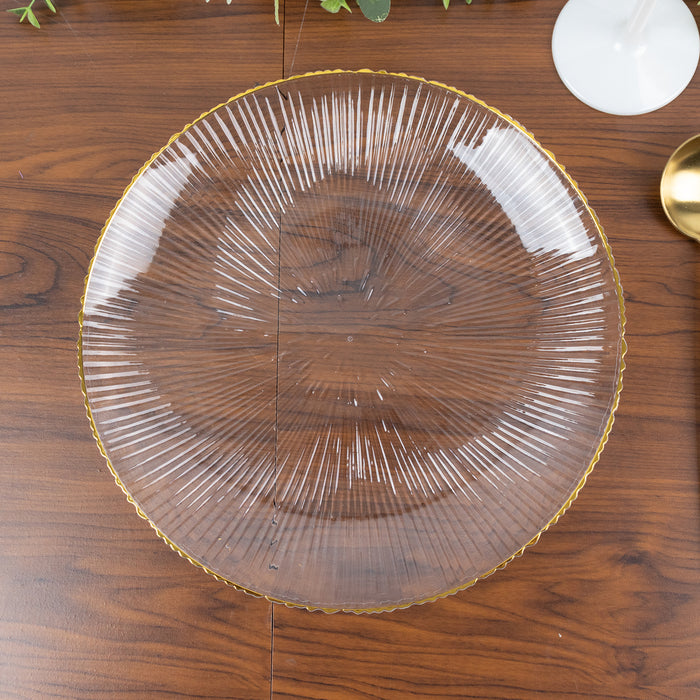Clear glass plate with textured lines and gold rim on wooden surface.