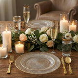 Elegant dinner table setup with candles, flowers, and glassware.
