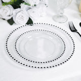 Clear glass charger plate with black beaded rim on a table setting.