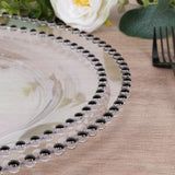 Elegant clear plate with black beaded rim on a wooden table.