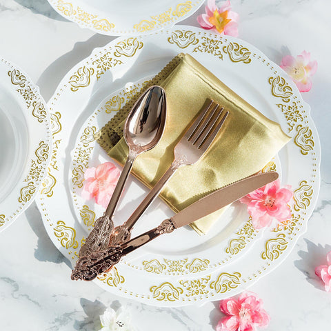 White plate with gold floral rim and gold flatware