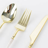 Gold plastic spoon, fork, and knife on white background