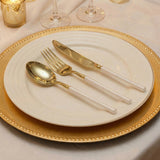 Gold and white elegant table setting with plate, spoon, fork, and knife
