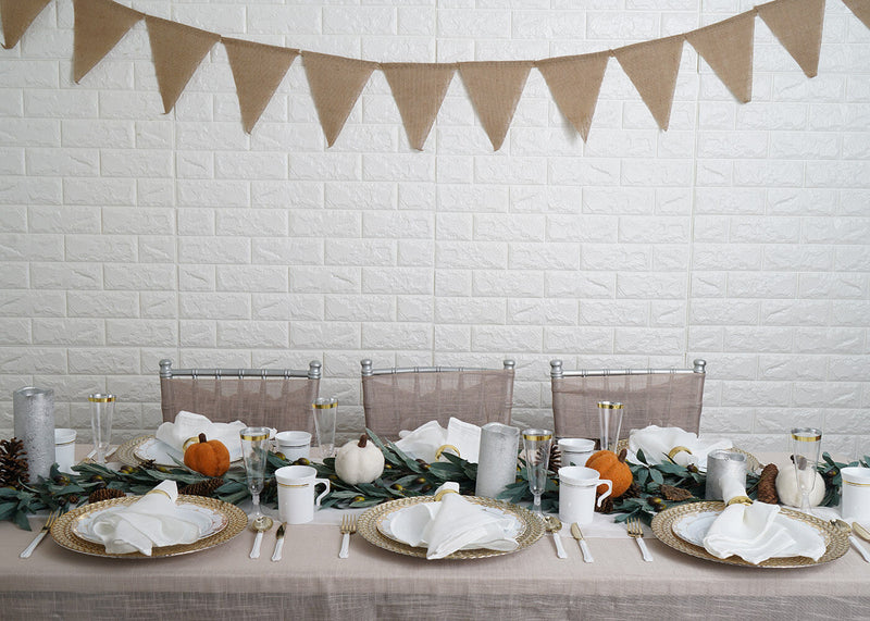 Wide dining table set for fall with pumpkins and greenery runner