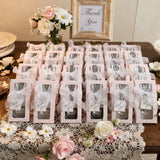 Wedding favor gift boxes arranged on a table with flowers and decor.