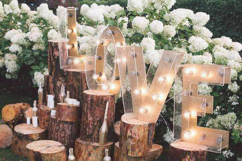 Lighted LOVE letters on tree stumps
