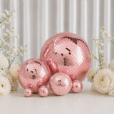 Pink mirror disco balls with white flowers on a soft pastel backdrop