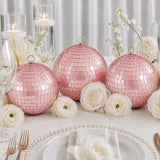Pink mirrored disco ball centerpieces with white flowers on elegant table setting