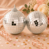 Silver disco ball ornaments with mirrored tiles on a peach floral background