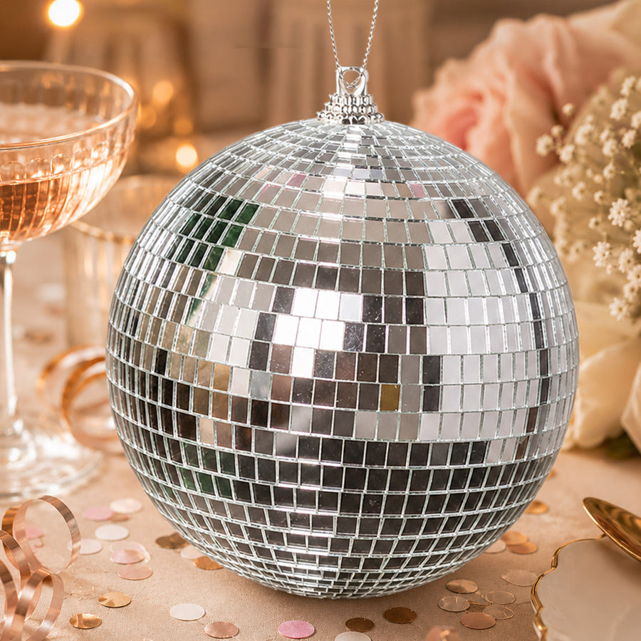 Silver disco ball ornament on a warm, elegant party table setting
