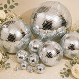 Silver mirrored disco balls and flowers on a beige background