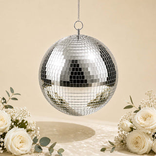 Silver disco ball hanging with white roses and floral decor on beige background
