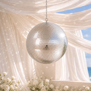 Elegant hanging disco ball under sheer drapery with white floral decor outdoors