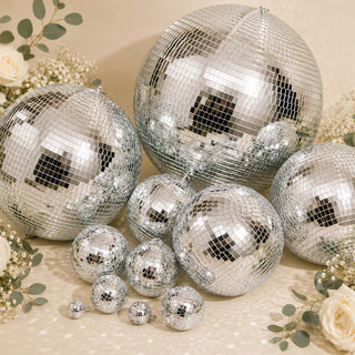 Silver disco ball balloons with floral accents on a beige party backdrop