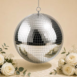 Silver hanging disco ball with floral arrangement on beige background