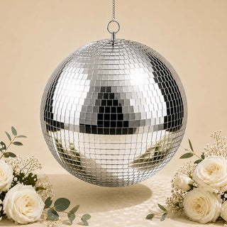 Silver hanging disco ball with floral arrangement on beige background