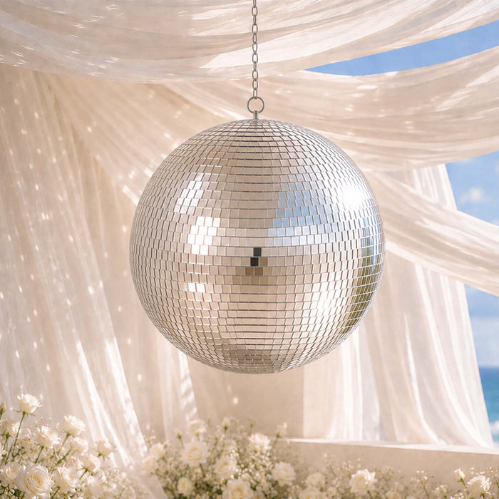 Silver disco ball hanging under draped fabric with white flowers and blue sky