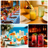 Colorful glassware displayed in various dining settings with fruits and decor.