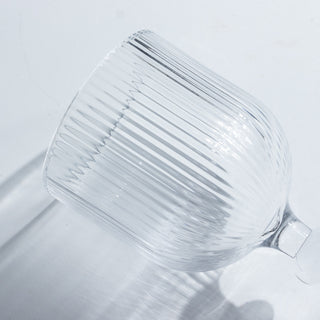 Ribbed glass wine goblet on a plain background
