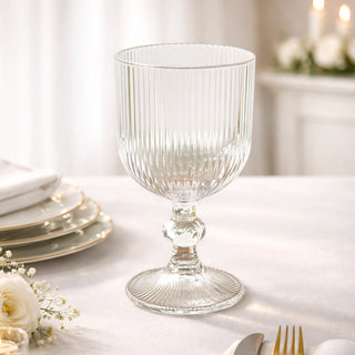Elegant ribbed glass goblet on a dining table setting.