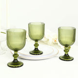 Green ribbed glass goblets on white table setting, elegant stemware set