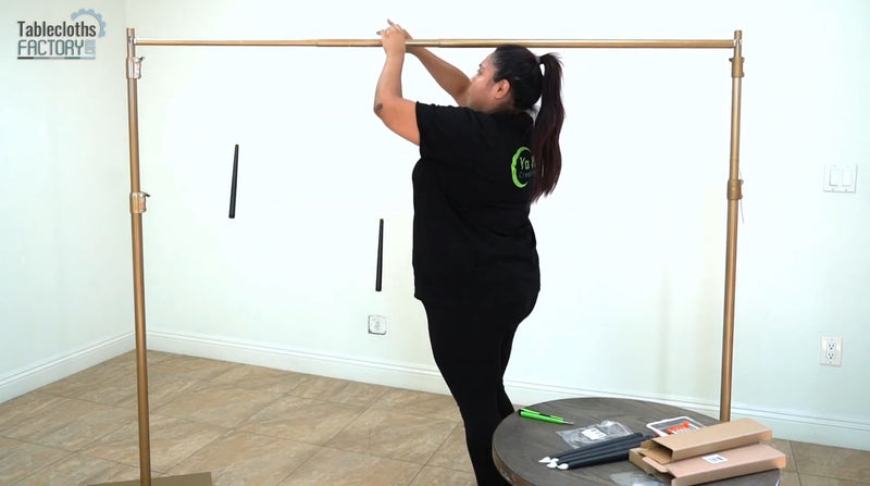 Hanging floating LED taper candles during a chic Halloween table setup with a gold backdrop.