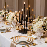 Elegant gold and black candlelit wedding table setting with white floral centerpieces