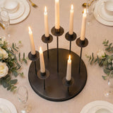 Elegant black candle centerpiece on a wedding reception table with floral decor