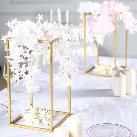 Gold tiered flower stand with white orchids and candles