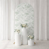Floral backdrop with white pedestals and decorative vases.