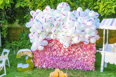 Ice cream party backdrop with rainbow balloon arch and floral wall