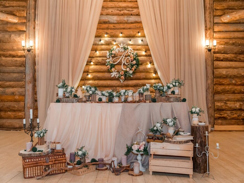 Rustic head table with burlap, white draping, and candles