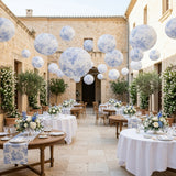 Elegant outdoor dining setup with floral decorations and hanging lanterns.
