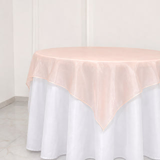 Round table with white skirt and blush pink sheer overlay tablecloth