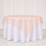 Blush pink sheer round table overlay on white banquet tablecloth