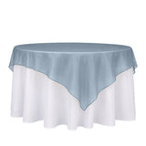 Round table with blue organza overlay and white tablecloth