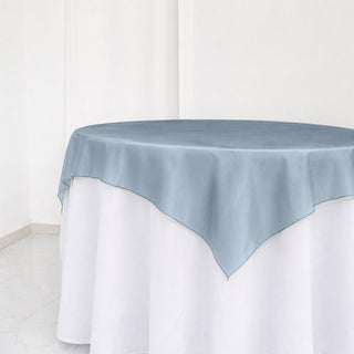 Light blue round tablecloth over white floor-length table cover
