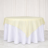 Yellow table overlay on a white round table against a plain backdrop.