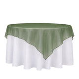 Green organza table overlay on white round tablecloth