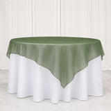 Green sheer overlay on round white tablecloth for elegant event table decor