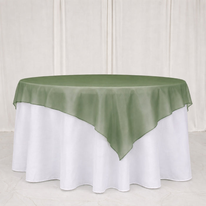 Green satin table overlay on white round banquet tablecloth